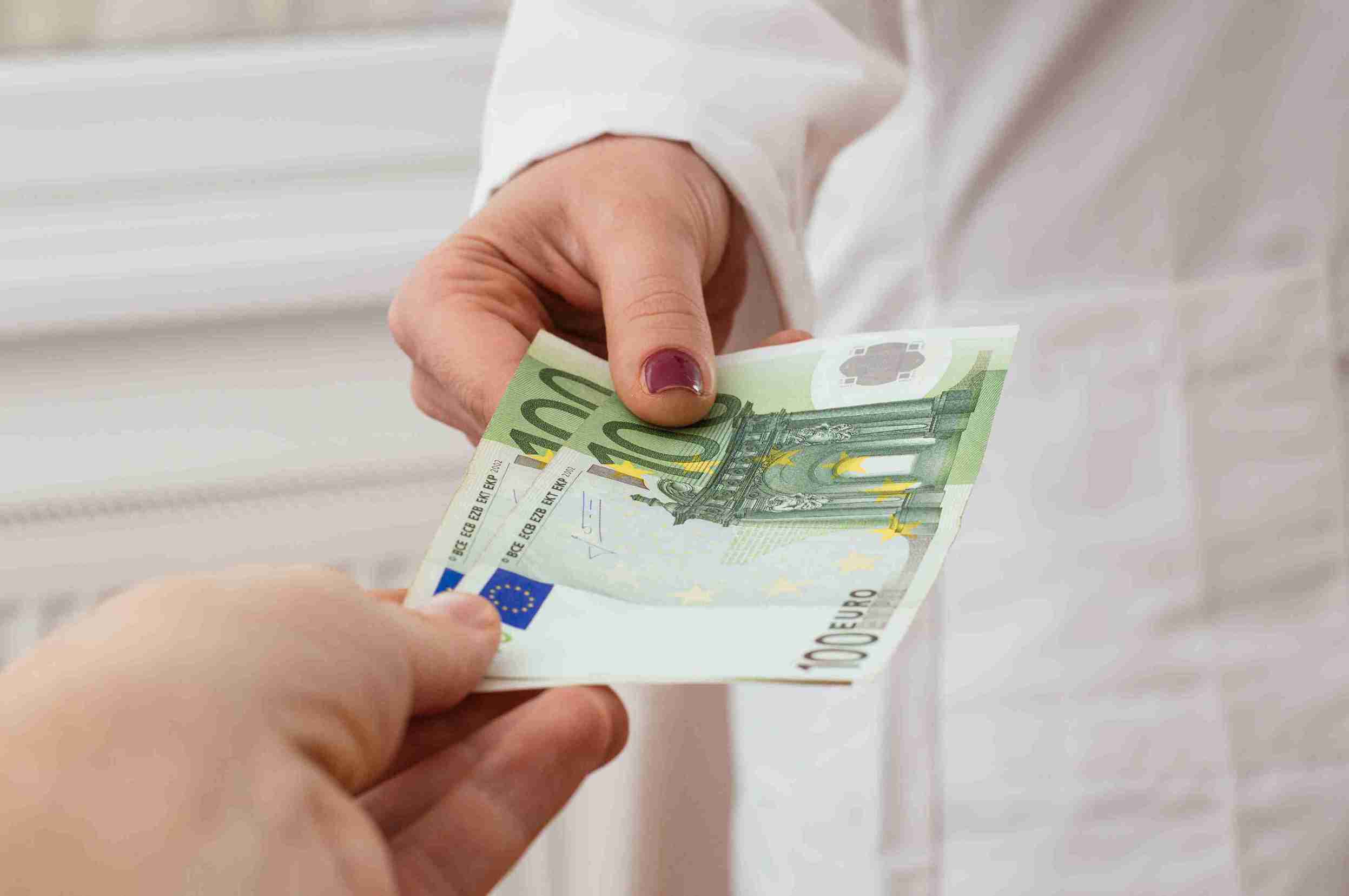 Mann gibt einer Ärztin Geld