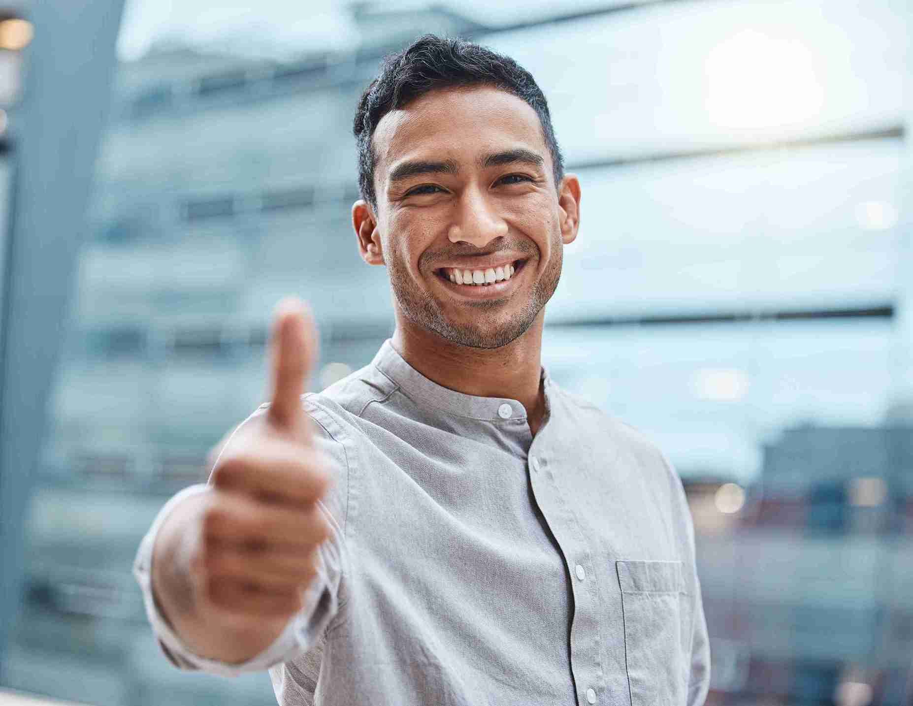 Hombre sonriente con el pulgar hacia arriba, simbolizando una alta tasa de éxito del injerto capilar