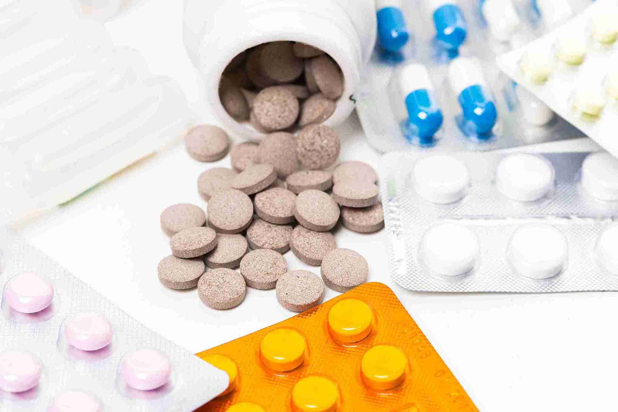 Verschiedene Tabletten und Kapseln in Blistern sowie lose Tabletten aus einer Dose, Symbolbild für Nahrungsergänzungsmittel und Medikamente – passend zum Thema Erfahrung mit Priorin.