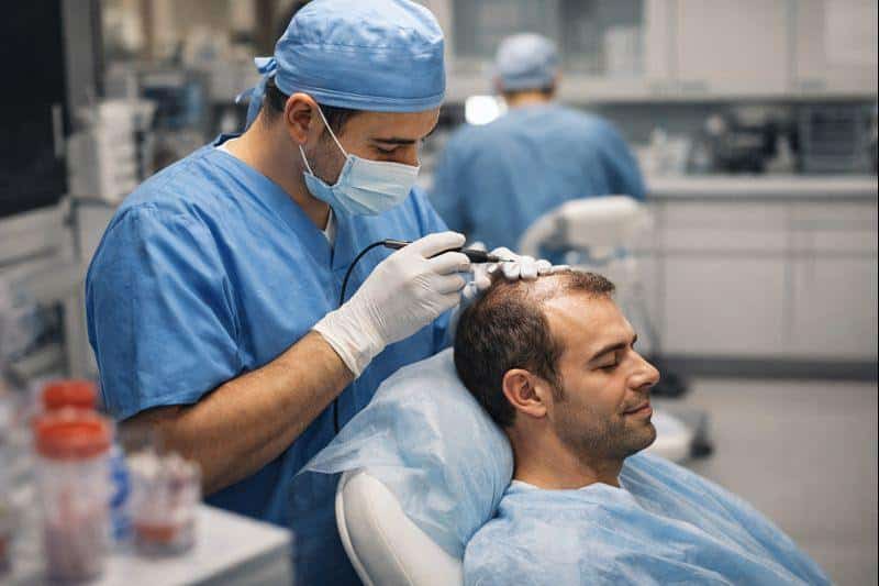 Doctor performing a hair transplant procedure in a professional clinic in Turkey.