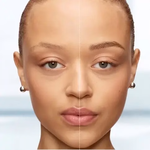 Rostro de una mujer mostrado en vista frontal, dividido por una línea vertical que compara el antes y después de un tratamiento estético de cejas, destacando una apariencia más definida y simétrica en un lado.